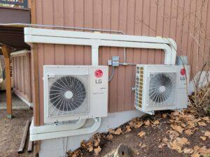 Dual LG Smart Inverter outdoor HVAC units installed on the side of a residential building, ensuring efficient heating and cooling for the home.