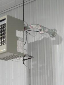 Ceiling-mounted heater installed in a commercial space, featuring secure ductwork and efficient heating for large areas.