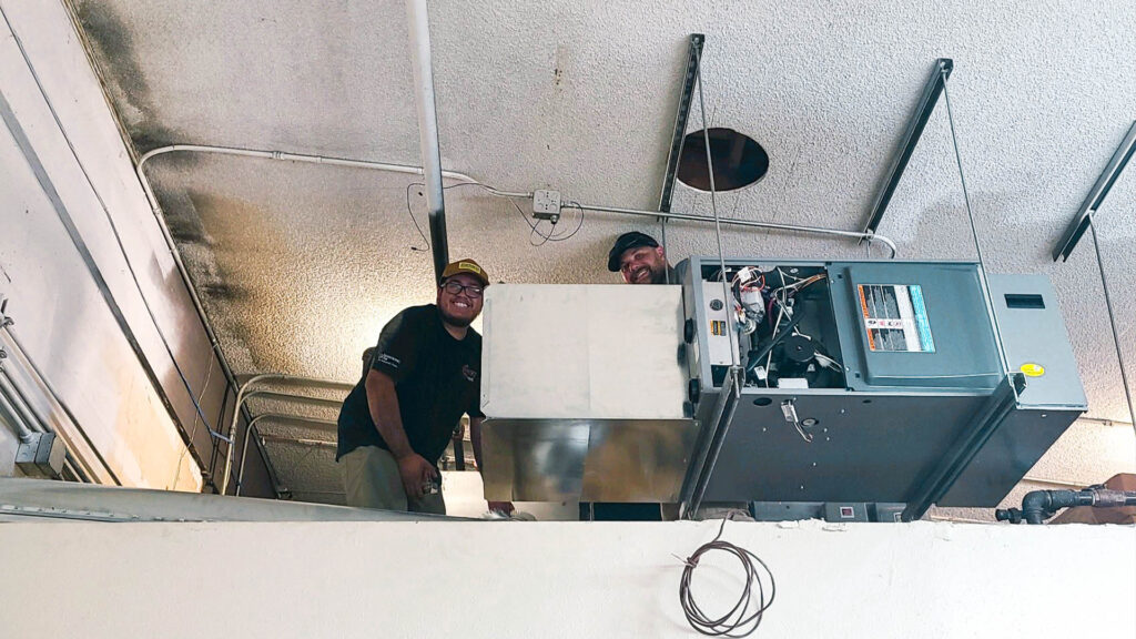 Two Strobel Custom Heating Workers by HVAC Unit