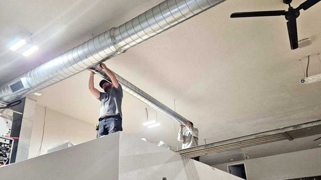 HVAC Professionals Installing Precision Ductwork in Commercial Building